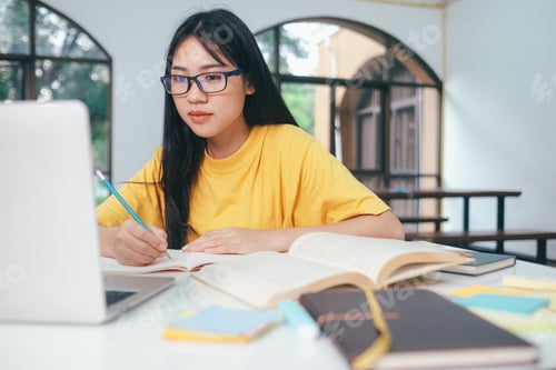 Preview: Young collage student using computer and mobile device studying online.