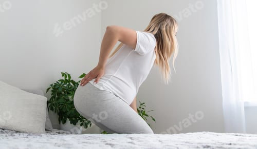 Preview: Pregnant woman hurts her back. Selective focus.