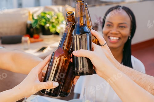 Preview: A black woman smiling at a toast with friends at sunset