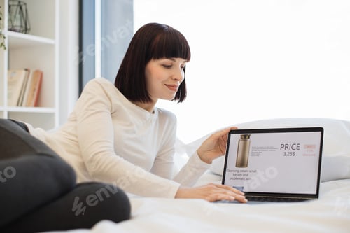 Preview: Woman using laptop for buying cosmetic online with discount