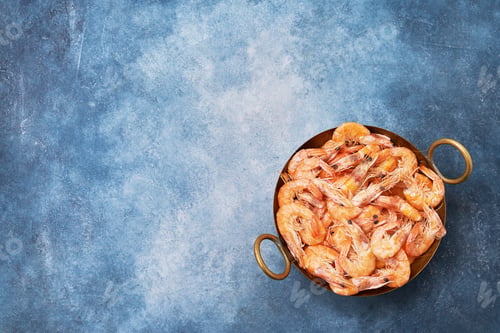 Preview: Cooked fresh shrimps on a vintage dish over blue background. Copy space, flat lay.