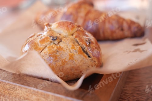Preview: Freshly baked pastries on wooden tray in cozy cafe