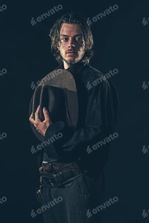 Preview: Vintage Cowboy Holding Hat In Hand. Young Man. Studio Shot.