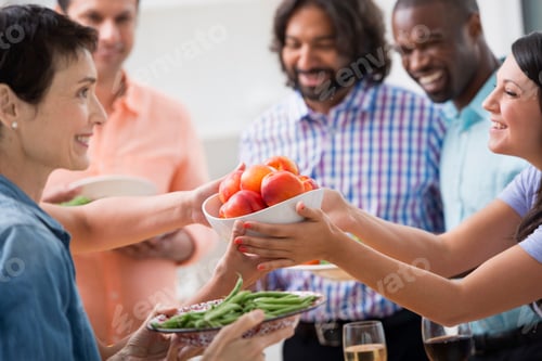 Preview: Colleagues at a working lunch, handing fresh vegetables around.