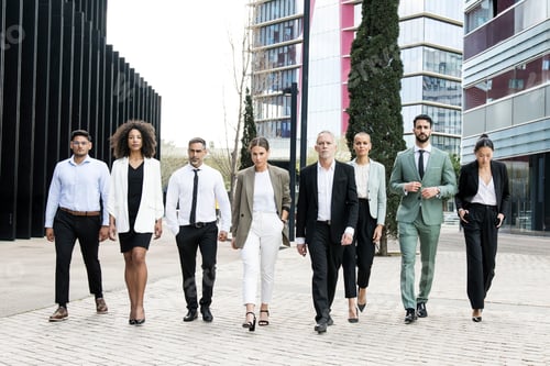 Preview: Group of confident business people walking the street together looking at camera. Diverse team of