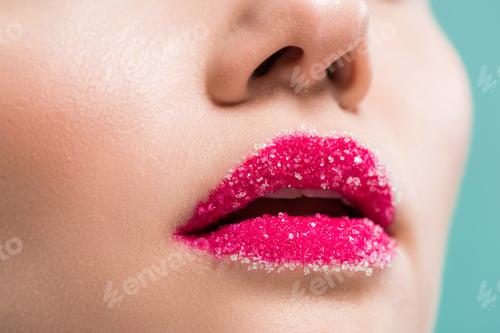 Preview: cropped view of woman with sugar on lips isolated on blue