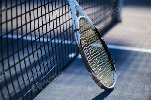 Preview: Tennis racquet is standing near tennis net
