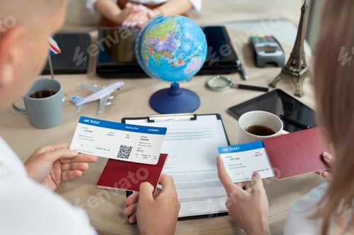 Preview: Close-up of passports and tickets in the hands of travelers at a travel agency