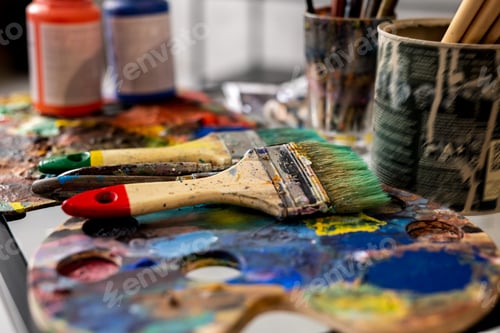 Preview: Group of paintbrushes and palettes on background of gouache jars