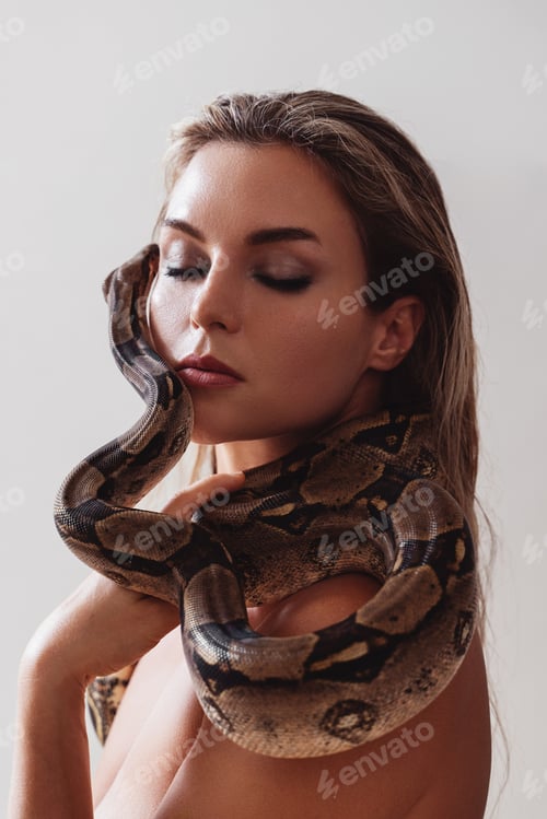 Preview: Beautiful woman with python snake elegantly slithering over her neck