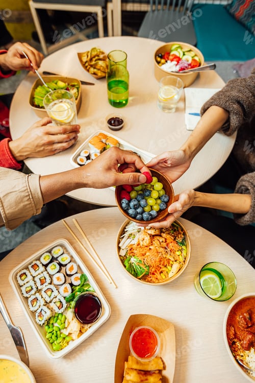 Preview: people at a table with food in their hands eating at a restaurant