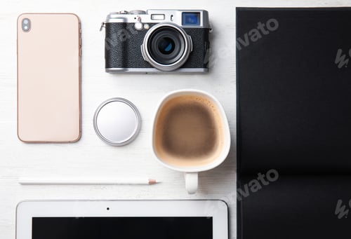 Preview: Flat lay composition with vintage camera and smartphone on white wooden table. Designer's workplace
