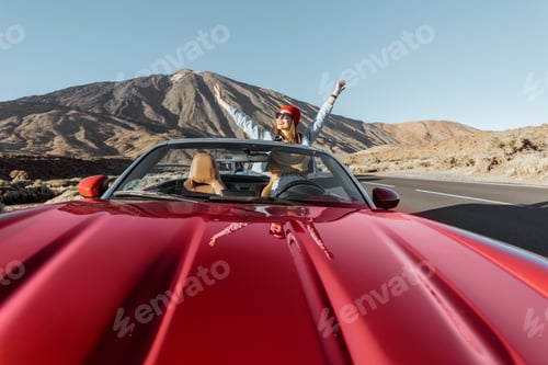 Preview: Woman traveling by cabriolet car on the volcanic valley