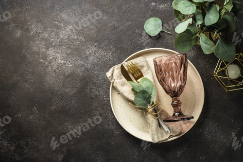 Preview: White craft plate, cutlery and green plants at black table.