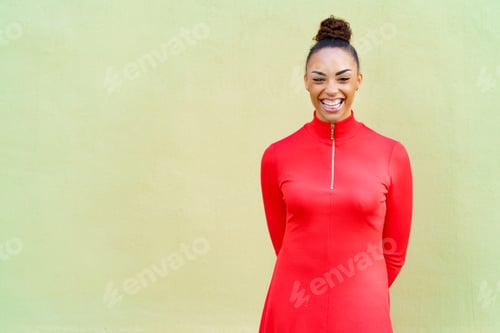 Preview: Young black woman in red dress smiling in urban background