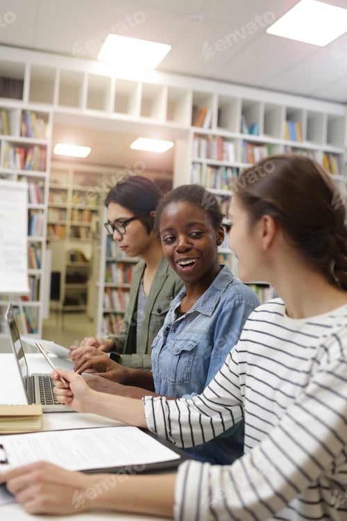 Preview: Students using laptop in the library