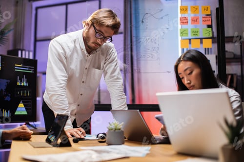 Preview: Multi ethnic company workers sitting at desk with gadgets