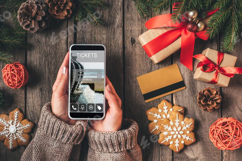 Preview: cropped view of woman using smartphone with ticket app on wooden background with credit card and