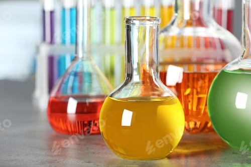 Preview: Florence flask with colorful liquid on grey stone table in laboratory