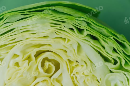 Preview: Halved cabbage top view flat lay over green background