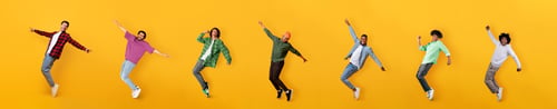 Preview: Happy multiethnic millennial guys dancing on colorful orange backgrounds