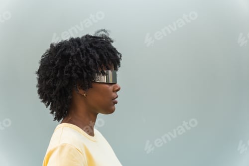 Preview: Profile of cool young woman wearing cyber glasses on bright blue background