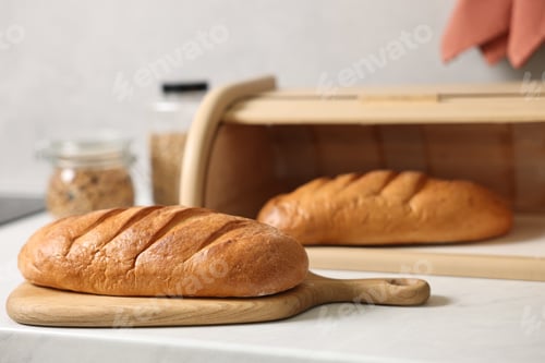 Preview: Wooden bread basket with freshly baked loaves on white marble table in kitchen