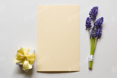 Preview: Green branches with purple inflorescences and a gift box with a bow on a light background.