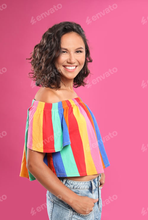 Preview: Happy young woman in casual outfit on pink background