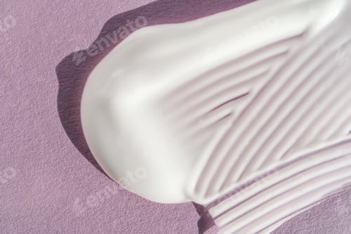 Preview: The texture of the white cream on a purple background.