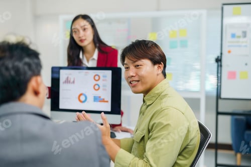Preview: Asian business team collaborating on data analytics presentation