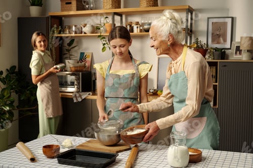 Preview: Senior Caucasian Woman Teaching Teenage Girl Baking Together in Kitchen