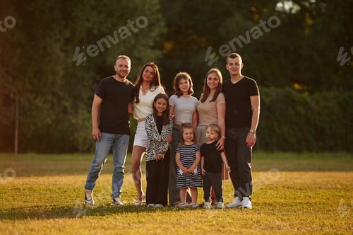 Preview: Looking forward. Family with adults and kids is standing on the field