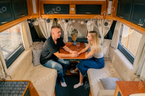 Preview: A couple in love a guy and a girl are sitting on date in a mobile home and gently holding hands