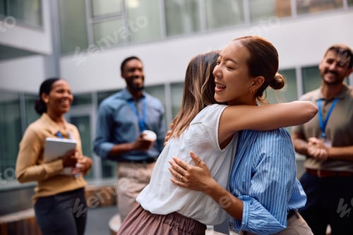 Preview: Female entrepreneurs embracing while celebrating their business success at work.