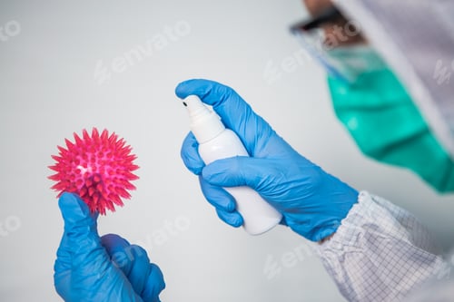 Preview: Doctor with protective suit and mask use sanitizer for Coronavirus red model.