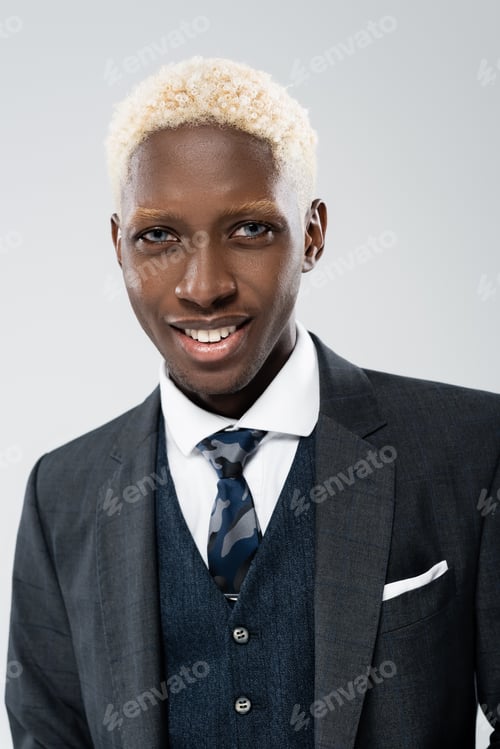 Preview: portrait of cheerful african american and young man in suit looking at camera isolated on grey