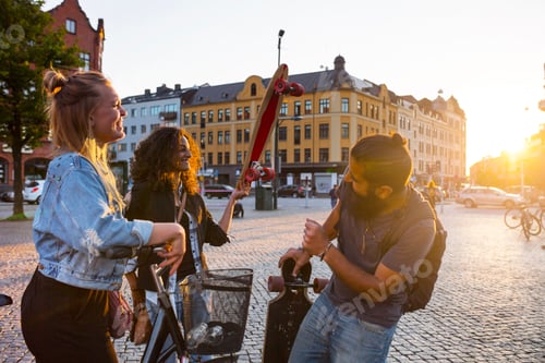 Preview: Smiling friends with bicycle and longboards in town square
