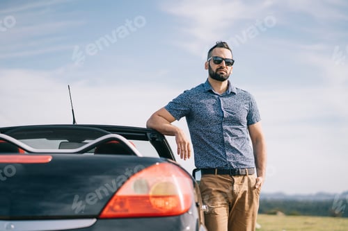Preview: Attractive man posing in convertible car.