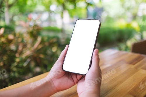 Preview: Mockup image of a woman holding mobile phone with blank white desktop screen in the outdoors