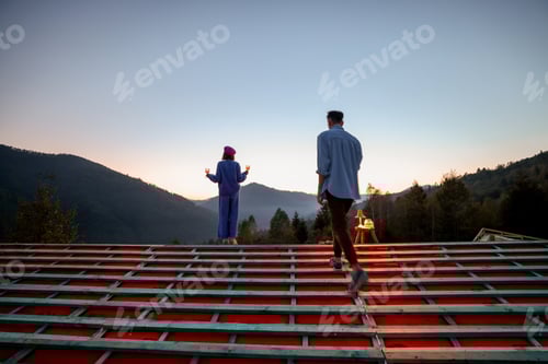 Preview: Man and woman enjoy beautiful sunset in the mountains