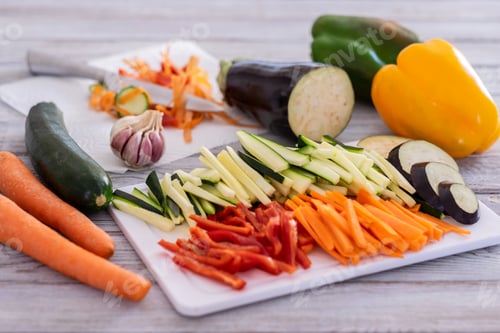 Preview: Fresh vegetables on a wooden table with a mix of sliced carrots, zucchini, courgettes, eggplant