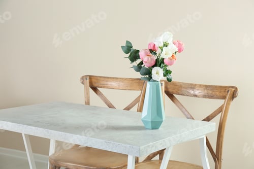 Preview: Vase with beautiful flowers as element of interior design on table in room. Space for text