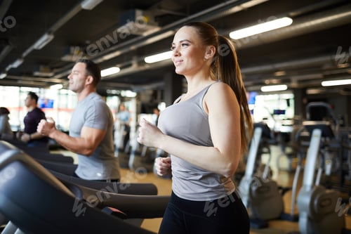 Preview: Couple Running on Tredmills in Gym