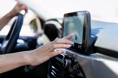 Preview: Woman driving car using navigation system on dashboard touchscreen