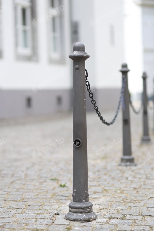 Preview: Outdoor scene featuring a metal pole standing in front of a white building