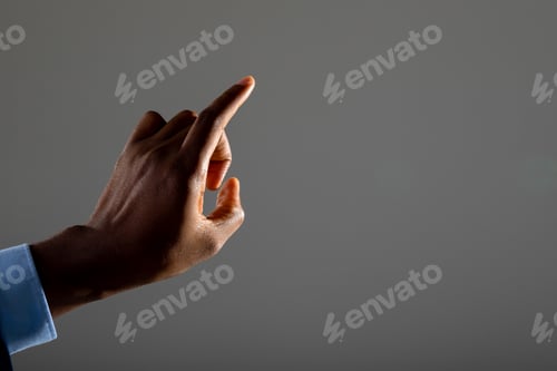 Preview: Close up of businessman touching invisible screen against grey background