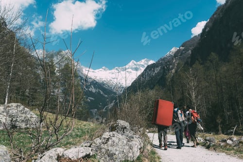 Preview: Rear view of adult friends with bouldering mat backpack walking along rural road, Lombardy, Italy