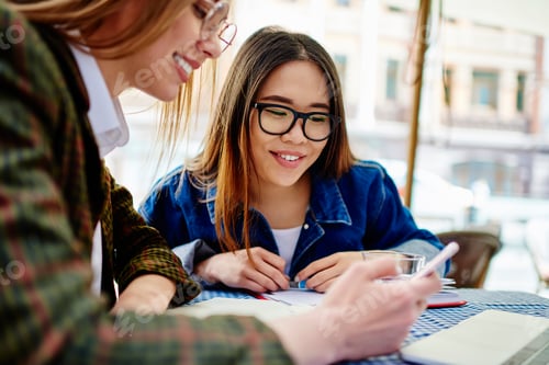 Preview: Positive female friends browsing mobile phone