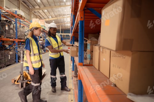Preview: Young man and woman working together in warehouse,